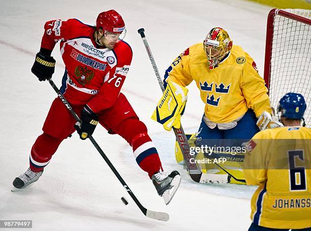 Russia's Evgeny Artyukhin, left, controls the puck in front of Sweden's goalie Jacob Markstrom during their Sweden vs. Russia match in the LG Hockey...