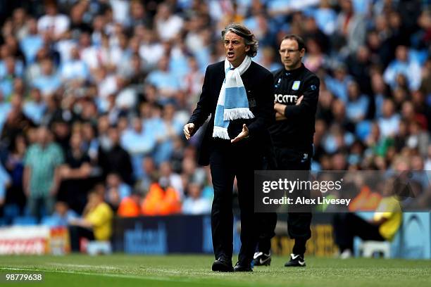 Roberto Mancini the Manchester City manager shouts instructions to his players as Martin O'Neill the Aston Villa manager looks on during the Barclays...