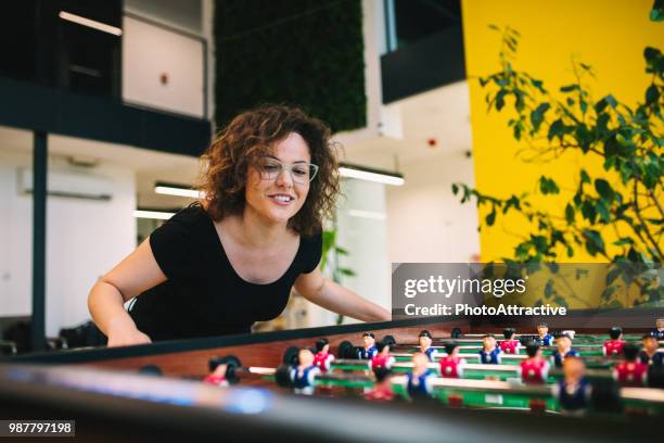 happy young women playing table football - office perks stock pictures, royalty-free photos & images