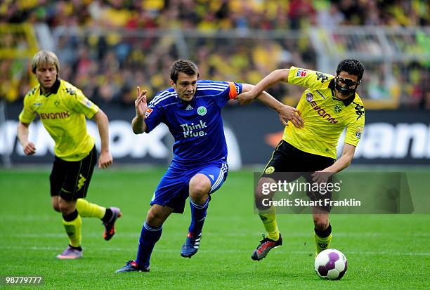 Nuri Sahin of Dortmund is challenged by Zvjezdan Misimovic of Wolfsburg during the Bundesliga match between Borussia Dortmund and VfL Wolfsburg at...