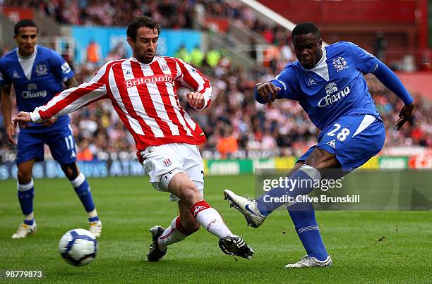 Victor Anichebe of Everton shoots past Danny Higginbotham of Stoke City during the Barclays Premier League match between Stoke City and Everton at...