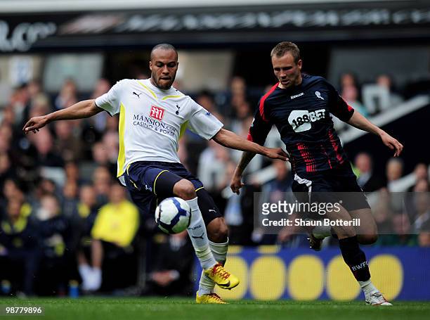 Younes Kaboul of Tottenham Hotspur is challeged by Matt Taylor of Bolton Wanderers during the Barclays Premier League match between Tottenham Hotspur...