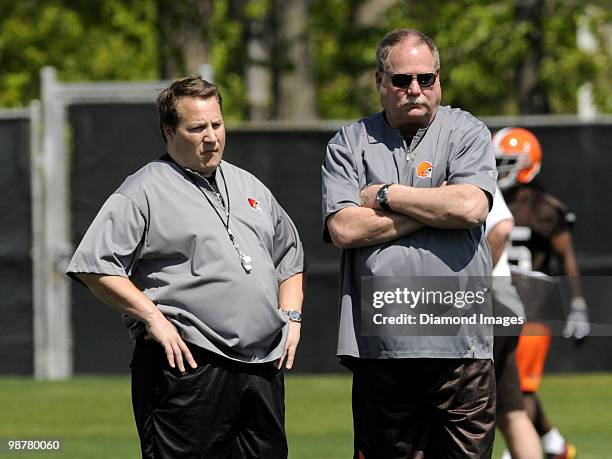 President Mike Holmgren of the Cleveland Browns and head coach Eric Mangini watch players go through drills during the team's rookie and free agent...