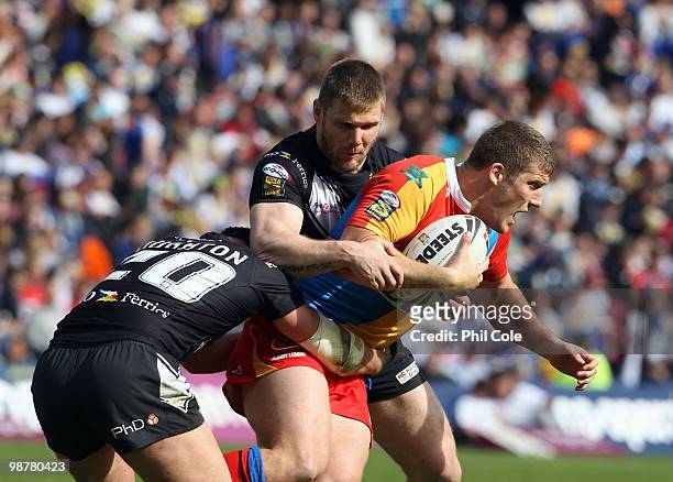 Tony Clubb of Harlequins gets tackled by Danny Houghton and Paul McShane during the Engage Rugby Super League Magic Weekend match between Hull FC and...