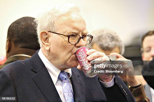 Warren Buffett, chief executive officer of Berkshire Hathaway, drinks a Cherry Coca-Cola as he tours the exhibition floor prior to the Berkshire...