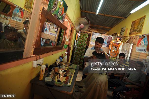 Sri Lankan soldier trims a customer's hair at a military-run salon in Mankulam on May 01, 2010. In the absence of civilian life, the military runs a...