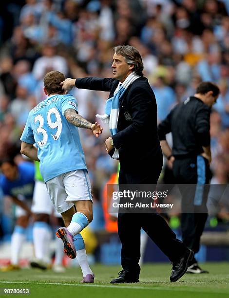 Craig Bellamy of Manchester City celebrates with his manager, Roberto Mancini after scoring his team's third goal during the Barclays Premier League...
