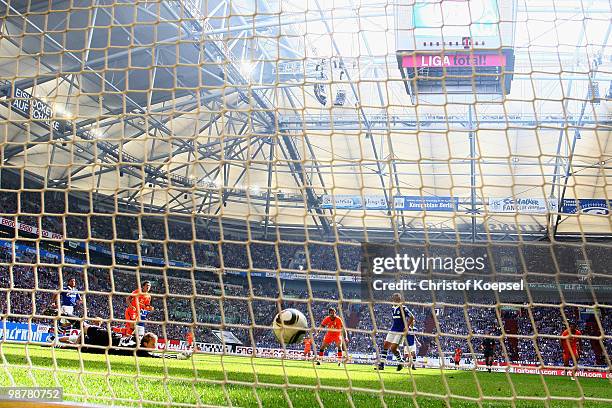 Mesut Oezil of Bremen scores the first goal against Manuel Neuer of Schalke during the Bundesliga match between FC Schalke 04 and SV Werder Bremen at...