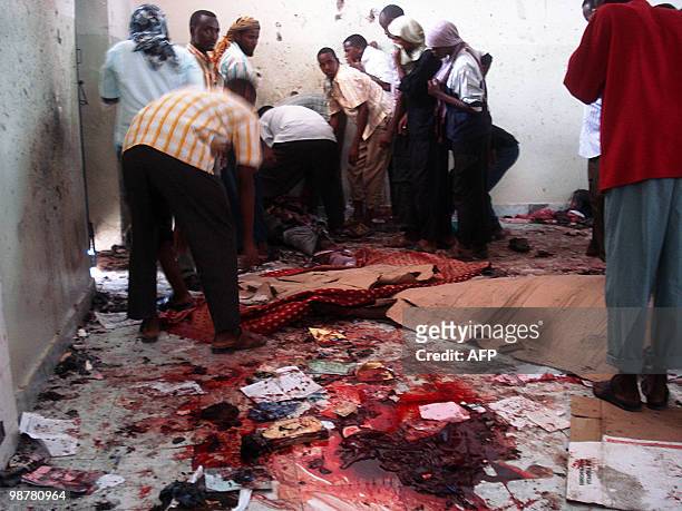 Residents of Mogadishu remove the bodies of victims on May 1, 2010 near Bakara market, killed after two explosions rocked a mosque in a crowded area...