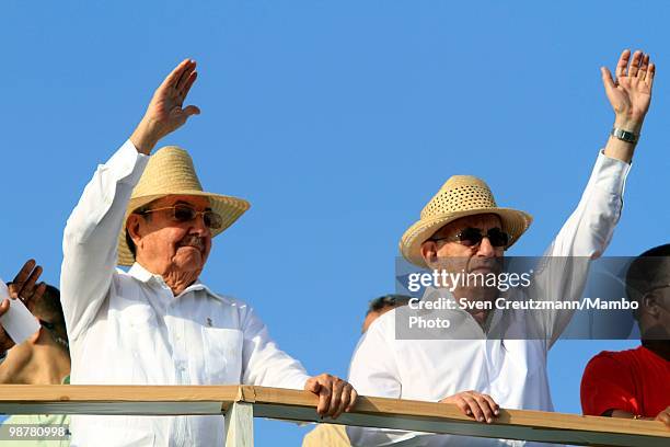 Cuba's President Raul Castro and Vice President Jose Ramon Machado Ventura wave as they observe the annual May Day parade of hundreds of thousands of...