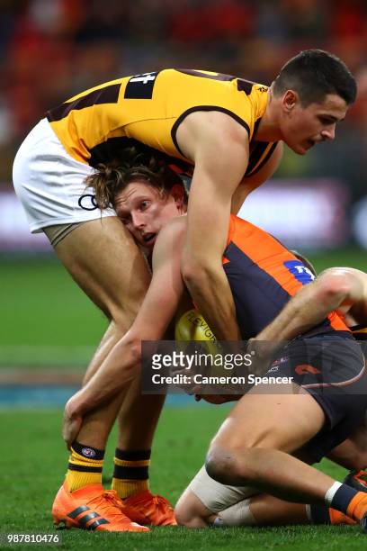 Lachie Whitfield of the Giants is tackled during the round 15 AFL match between the Greater Western Sydney Giants and the Hawthorn Hawks at Spotless...
