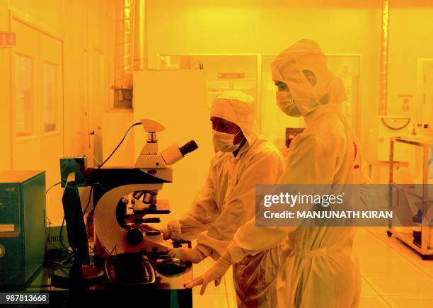 Researchers wearing bunny suits work inside the semiconductor fabrication lab at the Centre for Nano Science and Engineering , situated at the Indian...