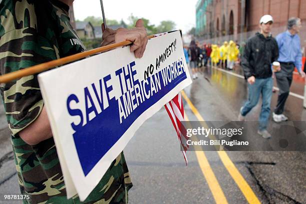 Protestor demonstrates outside the University of Michigan Stadium as people line up to get in to hear U.S. President Barack Obama's commencement...