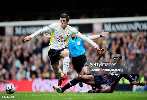 Gareth Bale of Tottenham Hotspur avoids a challenge from Fabrice Muamba of Bolton Wanderers during the Barclays Premier League match between...