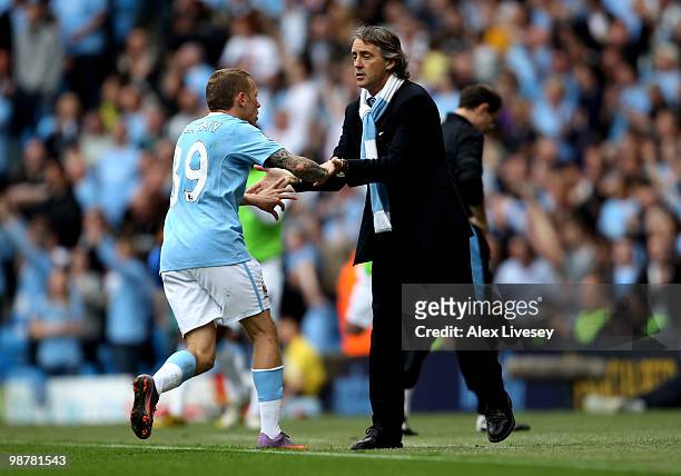 Craig Bellamy of Manchester City celebrates with his manager, Roberto Mancini after scoring his team's third goal during the Barclays Premier League...