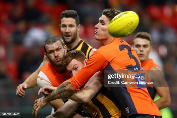 Tim O'Brien of the Hawks is tackled during the round 15 AFL match between the Greater Western Sydney Giants and the Hawthorn Hawks at Spotless...