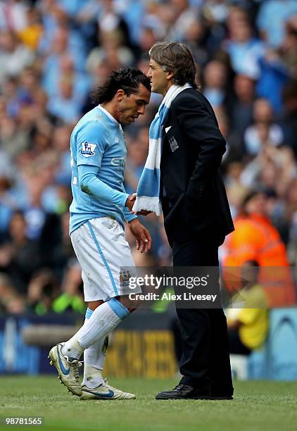 Carlos Tevez of Manchester City shakes hands with his manager, Roberto Mancini as he leaves the pitch after being substituted in the second half...