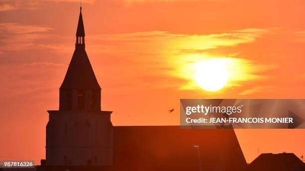 The Saint Jacques church, is silhouetted by the sun on June 29 in Illiers-Combray, center France. - The church "Saint Jacques" rebuilt between 1453...