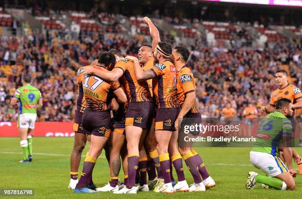 Anthony Milford of the Broncos is congratulated by team mates after scoring a try during the round 16 NRL match between the Brisbane Broncos and the...