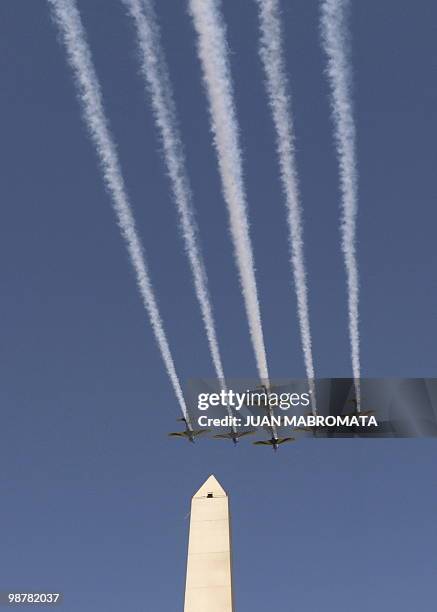 Seven Embraer EMB 312 Tucano aircrafts of the Brazilian Air Force's "Esquadrilha da Fumaça" fly in arrow formation over 9 de Julio avenue in Buenos...