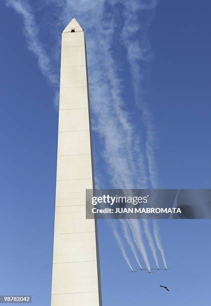 Seven Embraer EMB 312 Tucano aircrafts of the Brazilian Air Force's "Esquadrilha da Fumaça" fly in arrow formation over 9 de Julio avenue in Buenos...