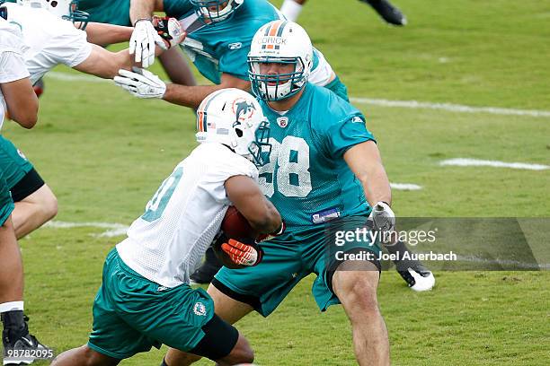 Jared Odrick defends as Tristan Davis of the Miami Dolphins carries the ball during the rookie mini camp May 1, 2010 at the Miami Dolphins training...