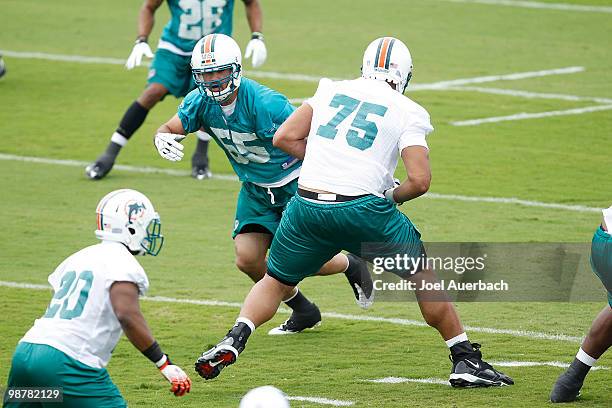 Koa Misi eludes the block by Kris Doura of the Miami Dolphins during the rookie mini camp May 1, 2010 at the Miami Dolphins training facility in...