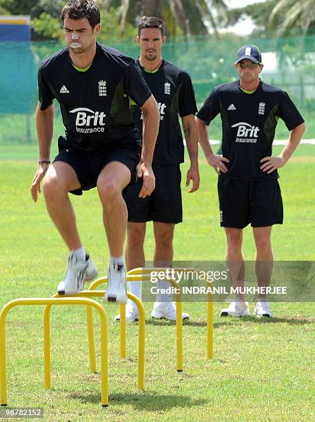 England cricketer James Anderson watched by teammates Kevin Pietersen and Paul Collingwood performs a exercise during a training session at the...