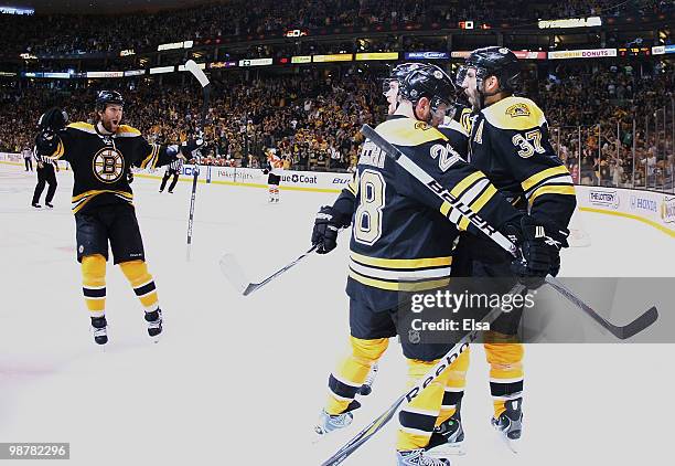 Patrice Bergeron of the Boston Bruins celebrates his goal with teammates Mark Recchi and Dennis Wideman in the first period against the Philadelphia...