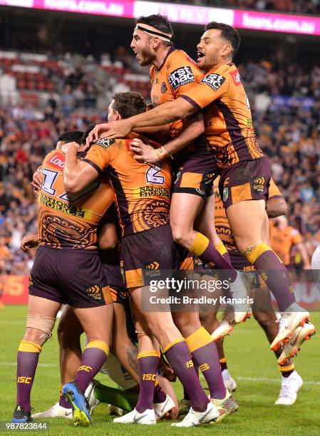 Anthony Milford of the Broncos is congratulated by team mates after scoring a try during the round 16 NRL match between the Brisbane Broncos and the...