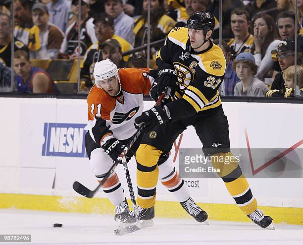 Zdeno Chara of the Boston Bruins passes the puck as Blair Betts of the Philadelphia Flyers tries to steal in Game One of the Eastern Conference...