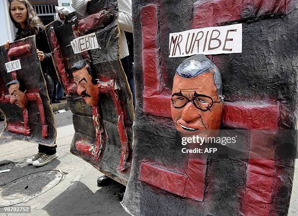 Un grupo de activistas muestran un cartel contra el presidente de Colombia Alvaro Urube durante de la marcha del dia del Trabajador en el centro de...