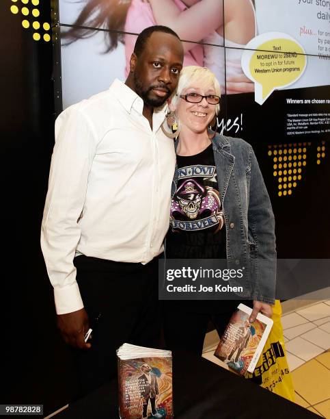 Musician Wyclef Jean poses for a photo with a participant at the Western Union "Returns the Love" to Mothers meet and greet at 1440 Broadway on May...