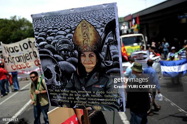 Unionists carry a poster with a picture of president-elect Laura Chinchilla dressed in military uniform and wearing religious headgear during a...