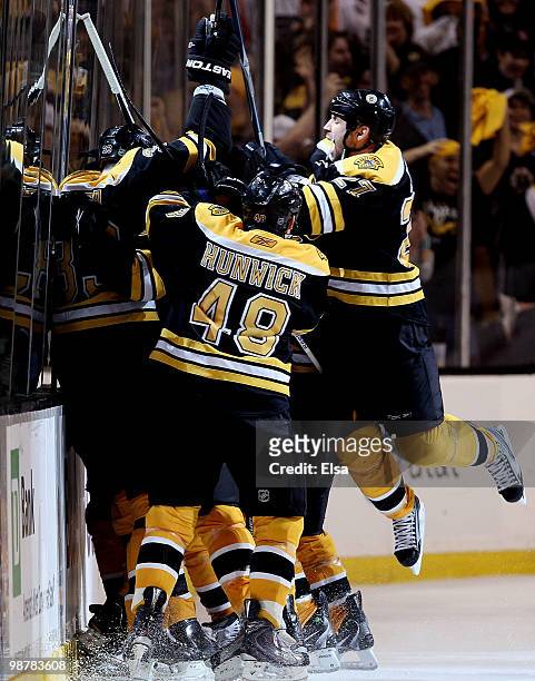 Marc Savard of the Boston Bruins is swarmed by teamamtes Matt Hunwick and Steve Begin after Savard scored the game winning goal in overtime against...