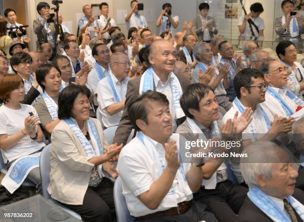 People celebrate in Nagasaki, southwestern Japan, on June 30 after UNESCO decided earlier in the day to add 12 sites linked to the history of the...