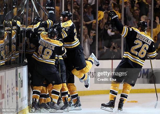 Marc Savard of the Boston Bruins is swarmed by teamamtes Matt Hunwick,Steve Begin and Blake Wheeler after Savard scored the game winning goal in...