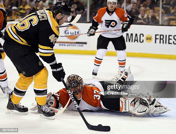 David Krejci of the Boston Bruins gets the puck past Brian Boucher of the Philadelphia Flyers to score in the third period in Game One of the Eastern...