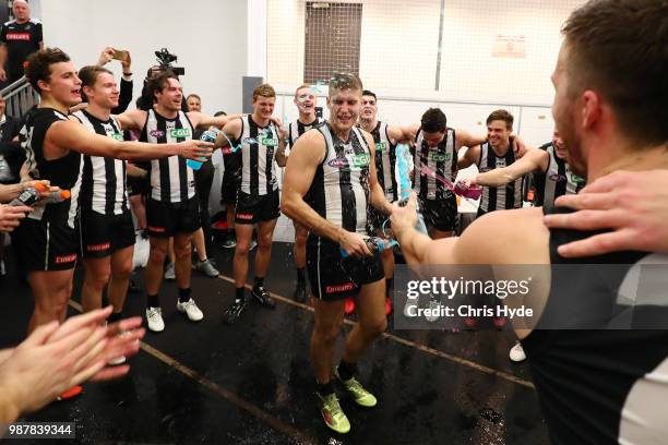 Brayden Sier of the Magpies sings the team song after winning the round 15 AFL match between the Gold Coast Suns and the Collingwood Magpies at...