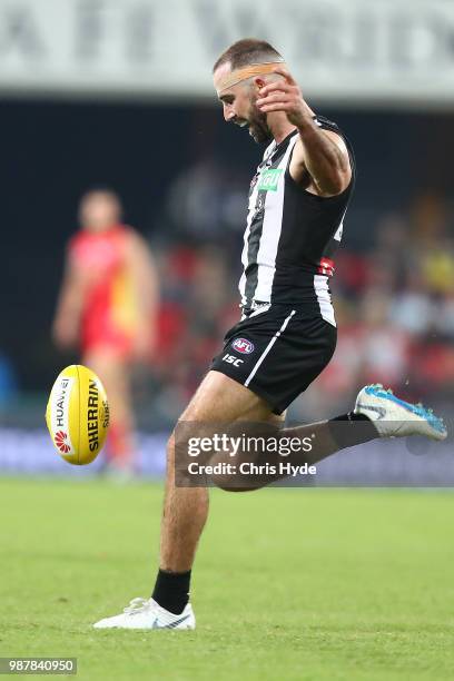 Steele Sidebottom of the Magpies kicks during the round 15 AFL match between the Gold Coast Suns and the Collingwood Magpies at Metricon Stadium on...