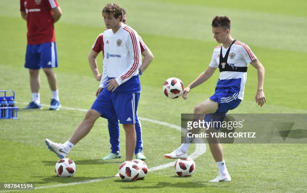 Russia's defender Mario Fernandes and teammate defender Andrey Semyonov attend a training session in Novogorsk, outside Moscow, on June 30 during the...