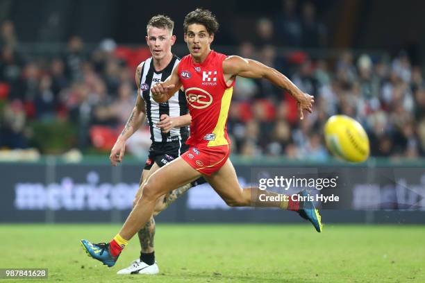 Ben Crocker of the Magpies and Sean Lemmens of the Suns compete for the ball during the round 15 AFL match between the Gold Coast Suns and the...