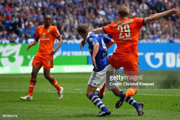 Per Mertesacker of Bremen fouls Benedikt Hoewedes of Schalke in the penalty area during the Bundesliga match between FC Schalke 04 and SV Werder...