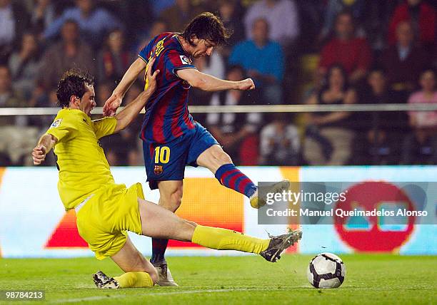 Lionel Messi of FC Barcelona shots to score in front of Diego Godin of Villarreal CF during the La Liga match between Villarreal CF and FC Barcelona...