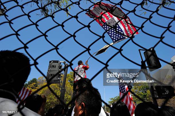 Man waves an American flag during a May Day immigration rally on May 1, 2010 in Los Angeles, California. More than 100,000 people were expected to...