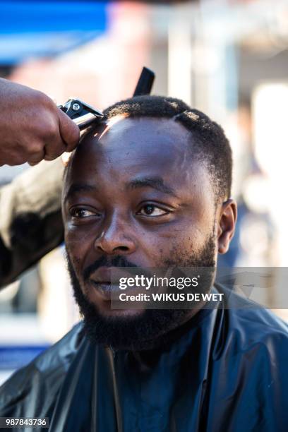 Man has his haircut as part of the centenary celebrations of the birth of South Africa's first black leader Nelson Mandela following the theme 'Be...