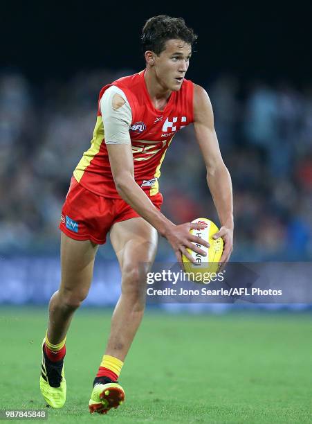 Wil Powell of the Suns looks to kick during the round 15 AFL match between the Gold Coast Suns and the Collingwood Magpies at Metricon Stadium on...