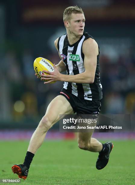 Jaidyn Stephenson of the Magpies runs with the ball during the round 15 AFL match between the Gold Coast Suns and the Collingwood Magpies at Metricon...