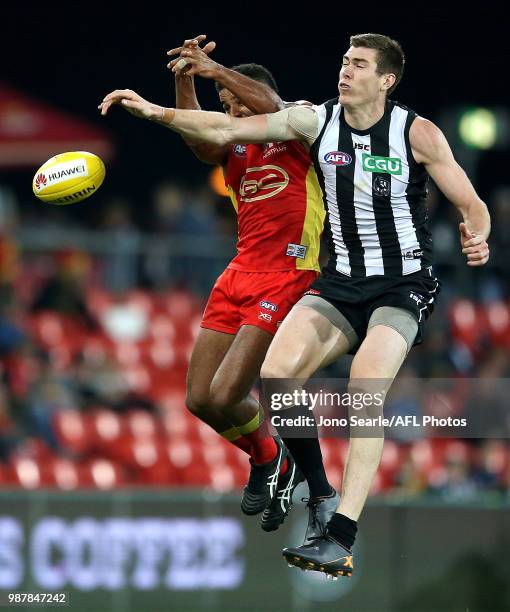 Touk Miller of the Suns competes with Mason Cox of the Magpies during the round 15 AFL match between the Gold Coast Suns and the Collingwood Magpies...