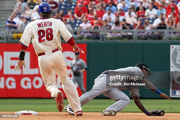 Jayson Werth of the Philadelphia Phillies is safe at second base as Jose Reyes of the New York Mets is pulled off the bag on a throwing error from...